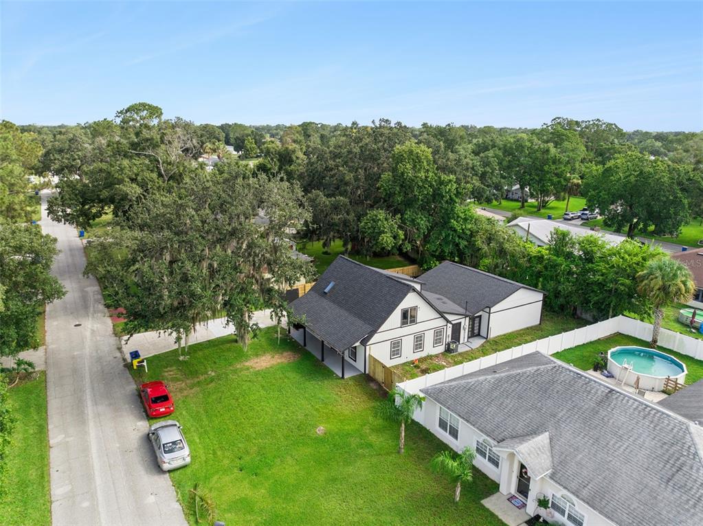 An aerial view shows a white house with a black roof and a backyard pool — 2713 VICTORY PALM DRIVE, EDGEWATER, FL