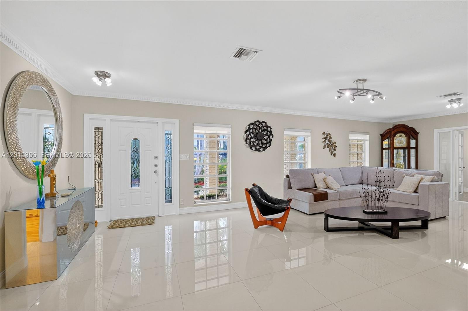 A bright living room features white tile floors, a gray sectional sofa, and a front door — 9261 SW 88 st, Miami FL 33176, MIAMI, FL