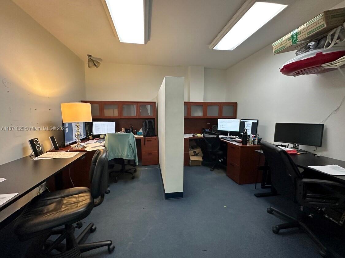 An office space features two desks separated by a partition wall with overhead storage cabinets — 2116 N Dixie Hwy, Hollywood FL 33020, HOLLYWOOD, FL