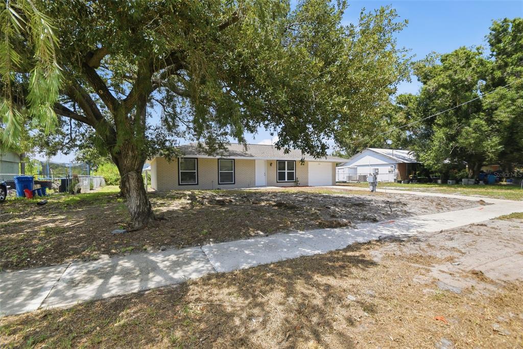 A single-story brick house with a large tree in the front yard — 1334 ATLANTIC DRIVE, RUSKIN, FL