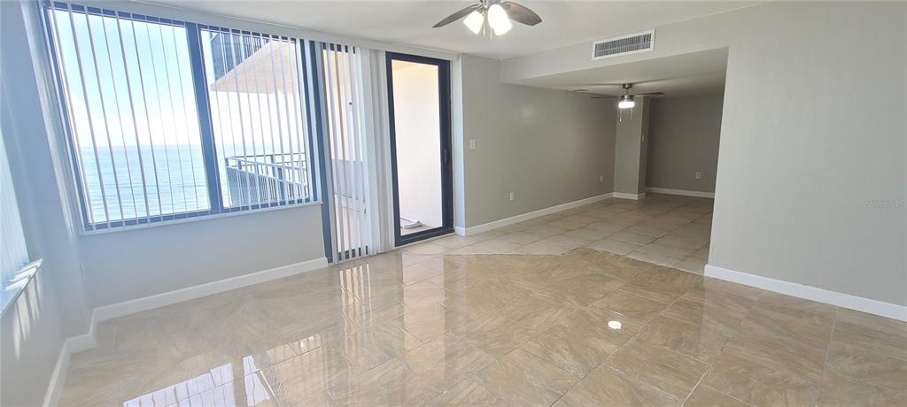 An open living area features light-colored tile flooring, a ceiling fan, and floor-to-ceiling windows — 3051 S ATLANTIC AVENUE UNIT 1904, DAYTONA BEACH SHORES, FL