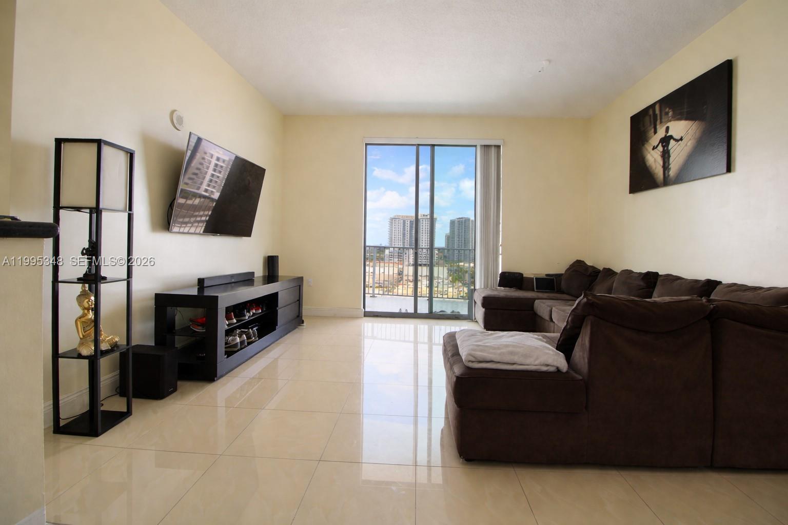 An empty room with beige walls, light tile flooring, and a sliding glass balcony door — 140 S Dixie Hwy # 1019, Hollywood FL 33020, HOLLYWOOD, FL