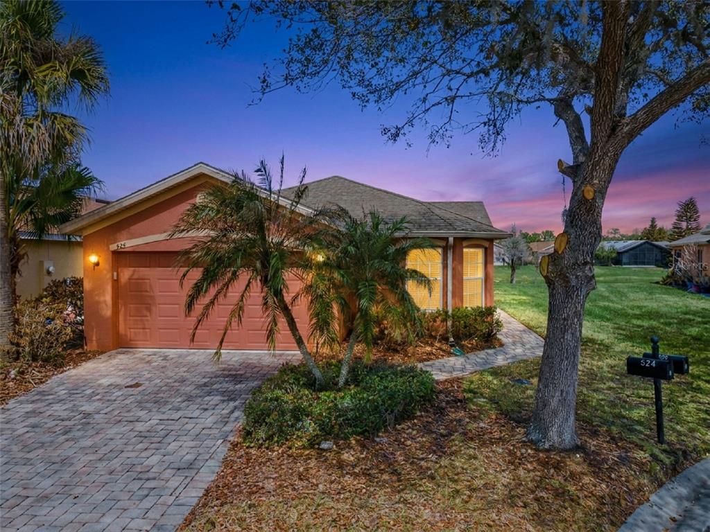 A single-story house with a terracotta exterior, a paved driveway, and a palm tree — 524 MURANO DRIVE, POINCIANA, FL