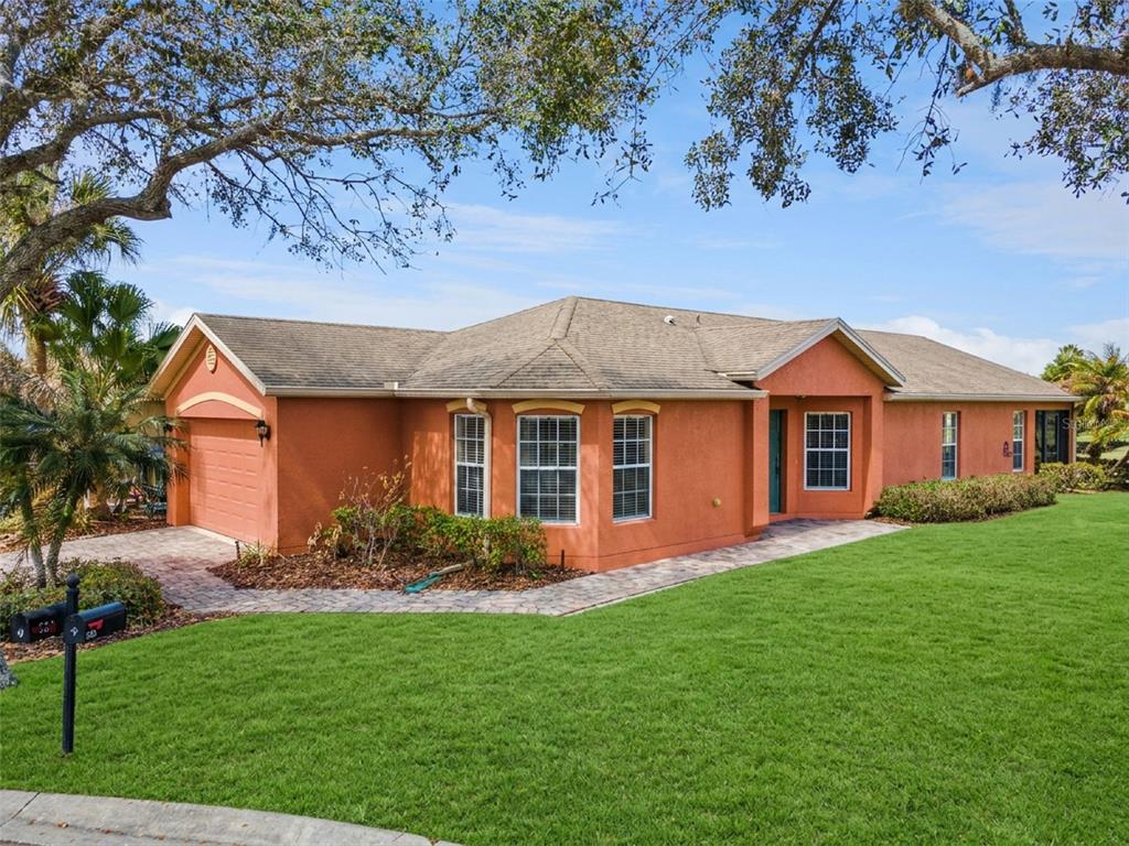 A single-story orange stucco house with a paved walkway and a large front lawn — 524 MURANO DRIVE, POINCIANA, FL