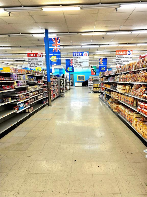 A grocery store aisle features shelves stocked with various products and overhead signage — 4626 S ORANGE BLOSSOM TRAIL, ORLANDO, FL