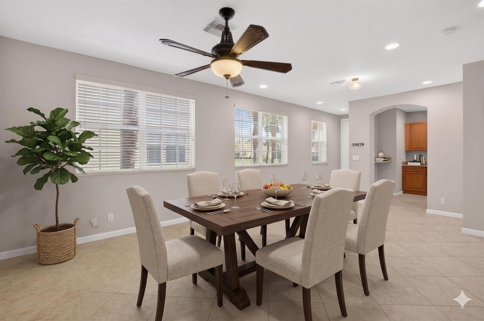 A dining room features a wooden table with six chairs, a ceiling fan, and tile flooring — 1418 W Wickham Circle # B, Delray Beach FL 33445, DELRAY BEACH, FL
