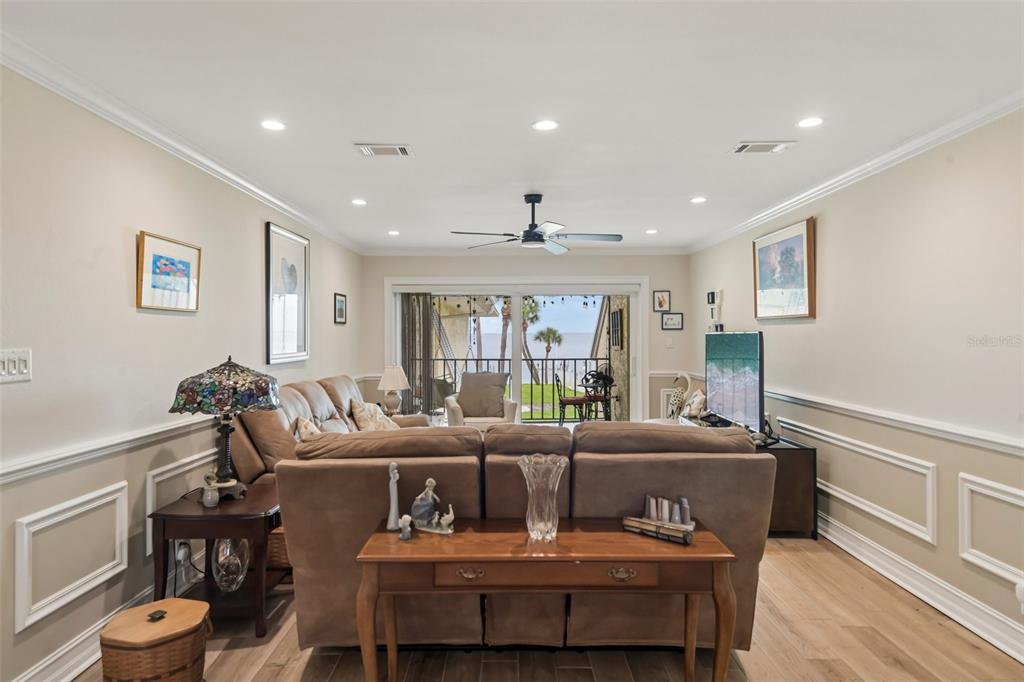 A living room features a brown sofa, a wooden console table, and a balcony view — 7300 SUNSHINE SKYWAY LANE UNIT 206, ST PETERSBURG, FL