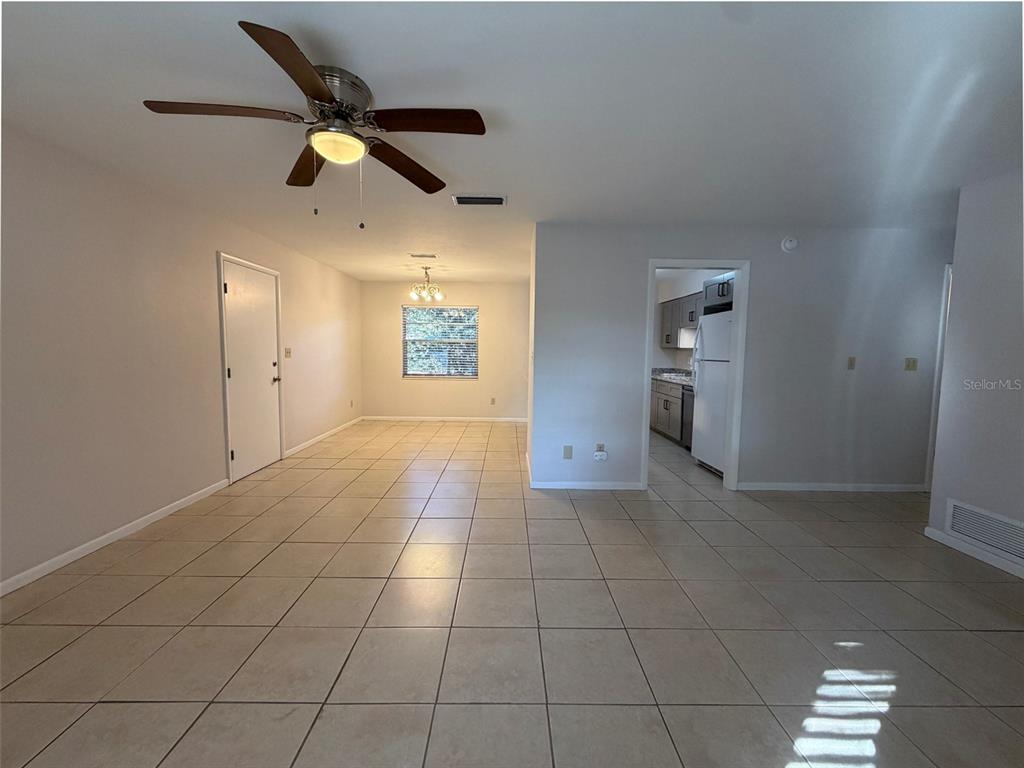 A living area with tiled floors, a ceiling fan, and an adjacent kitchen doorway — 3146 NW 46TH AVENUE, GAINESVILLE, FL