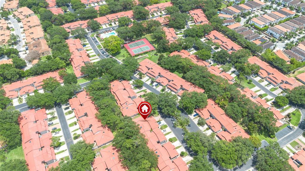 An aerial view shows a residential complex with red-tiled roofs and a central tennis court — 8237 BREEZE COVE LANE, ORLANDO, FL
