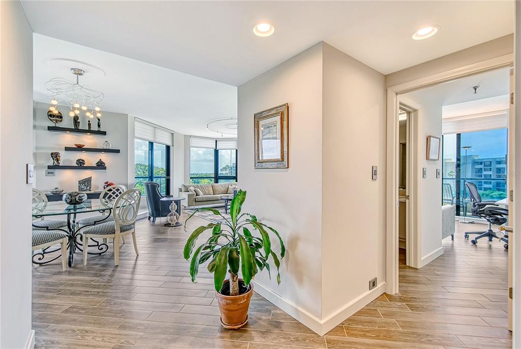 A bright interior view shows a dining area, living room, and hallway with wood flooring — 1211 GULF OF MEXICO DRIVE UNIT 302, LONGBOAT KEY, FL