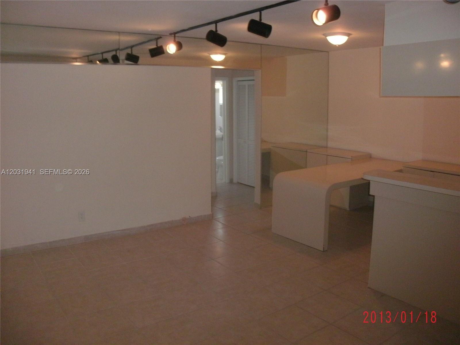 An interior room features tiled floors, a mirrored wall, track lighting, and a built-in desk — 2700 NE 135th St # 30, North Miami FL 33181, NORTH MIAMI, FL