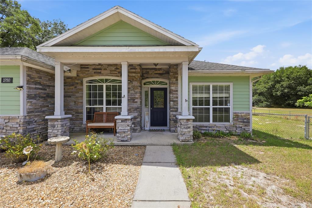 A single-story house features a stone facade, green siding, and a covered front porch — 2750 NW 174TH STREET, TRENTON, FL
