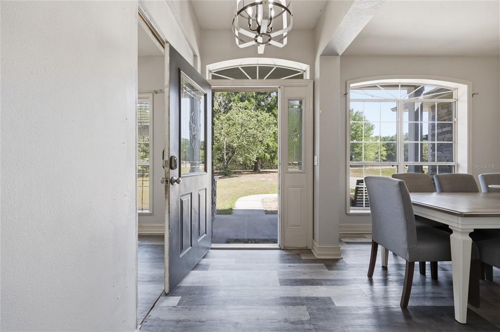 An open front door reveals a view of the outdoors from a dining room entryway — 2750 NW 174TH STREET, TRENTON, FL