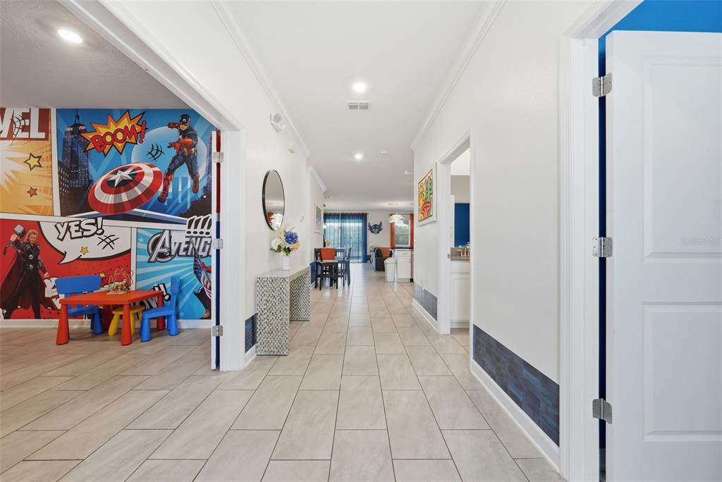 A hallway with tiled floors leads past a themed bedroom to an open living area — 4189 PARAGRAPH DRIVE, KISSIMMEE, FL