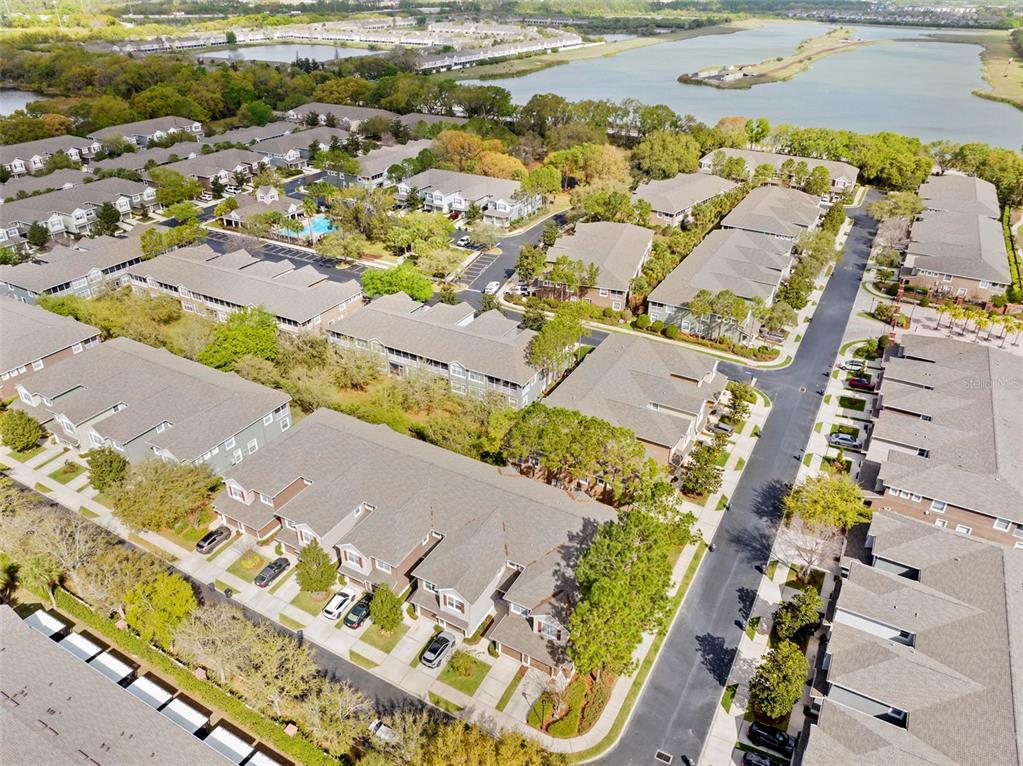 An aerial view shows multiple residential townhome buildings with gray roofs and surrounding green landscaping — 2105 KINGS PALACE DRIVE UNIT 2105, RIVERVIEW, FL
