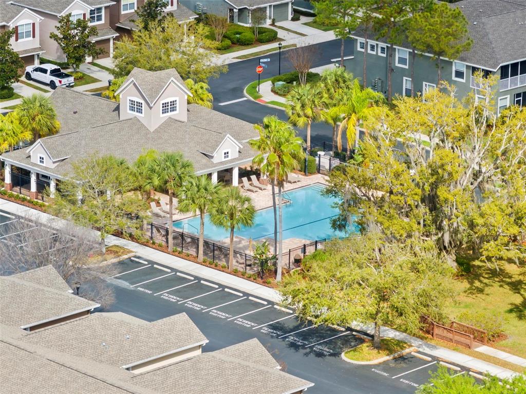 An aerial view shows a community swimming pool, clubhouse, and parking lot near residential buildings — 2105 KINGS PALACE DRIVE UNIT 2105, RIVERVIEW, FL