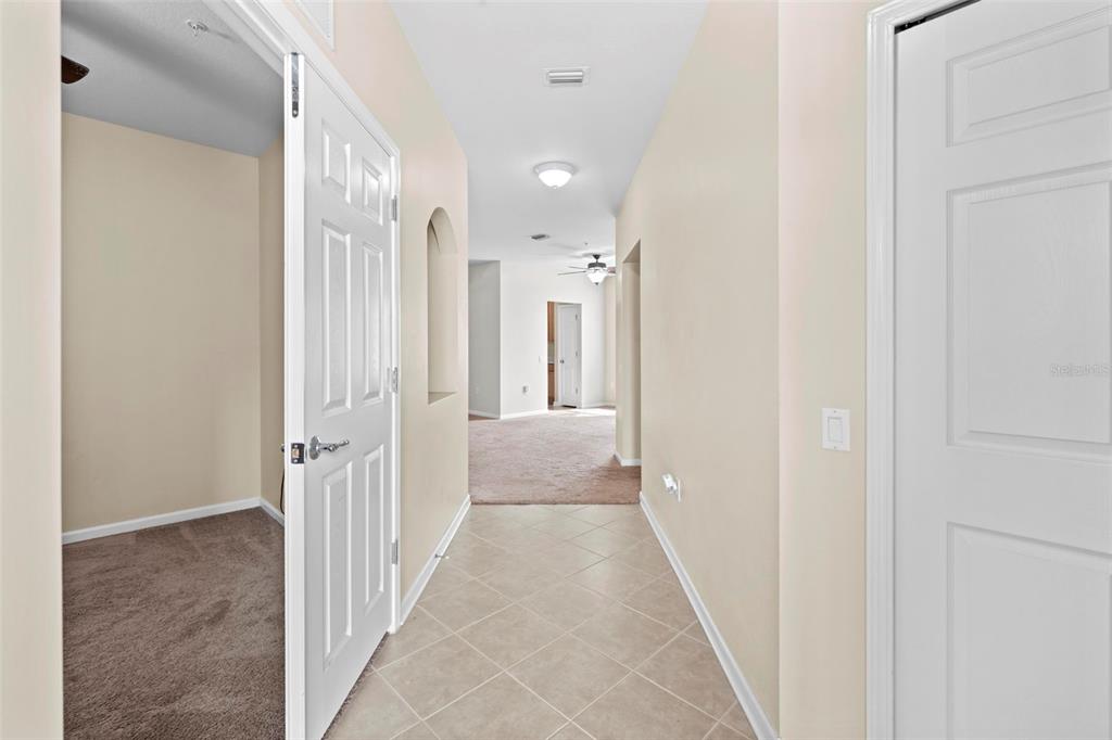 A hallway with tile flooring leads to a carpeted room through an open doorway — 2105 KINGS PALACE DRIVE UNIT 2105, RIVERVIEW, FL