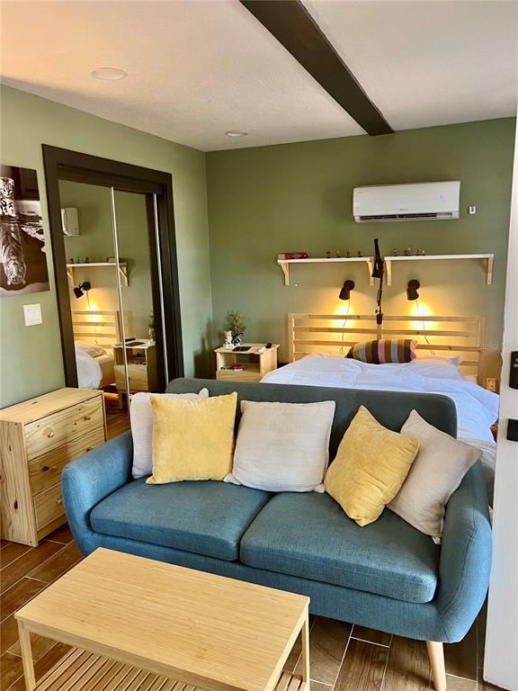 A studio room features a blue sofa, a bed, a wooden dresser, and green walls — 1014 W MOHAWK AVENUE, TAMPA, FL