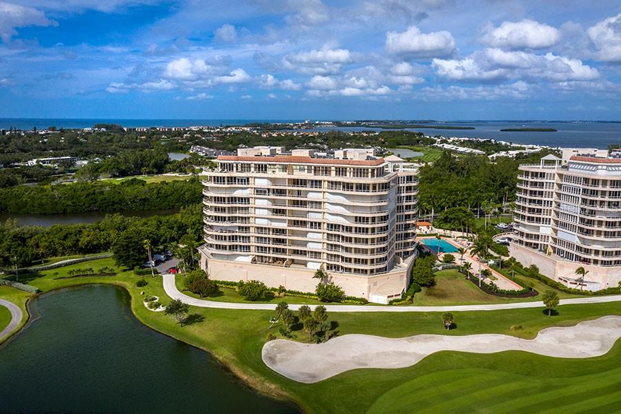 An aerial view of two large residential buildings situated next to a golf course and water — 3060 GRAND BAY BOULEVARD UNIT 172, LONGBOAT KEY, FL