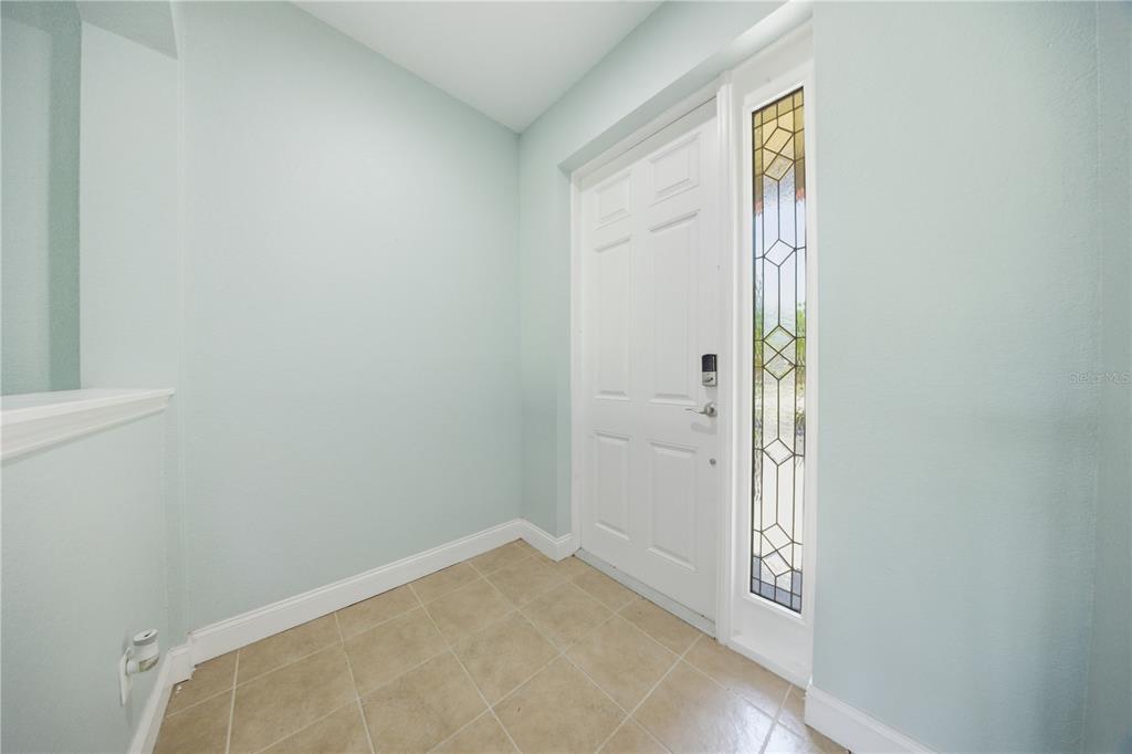 An entryway features light blue walls, tile flooring, and a white door with glass sidelights — 4620 1ST AVENUE E UNIT 4620, PALMETTO, FL
