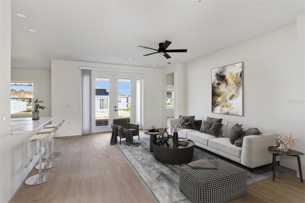 A modern living room features a white sofa, a black ceiling fan, and glass doors — 1201 APOPKA LANE, KISSIMMEE, FL