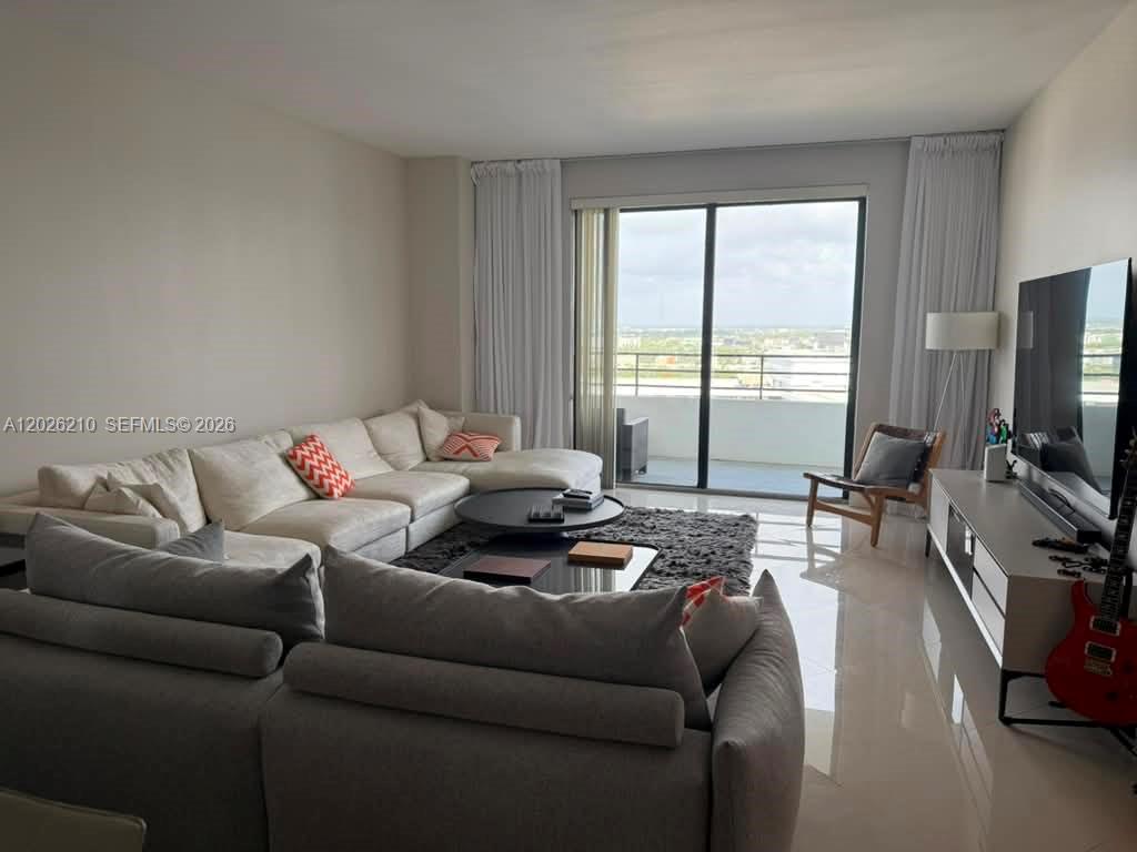A living room features a large sectional sofa, a coffee table, and a balcony view — 2500 Parkview Dr # 2518, Hallandale Beach FL 33009, HALLANDALE BEACH, FL