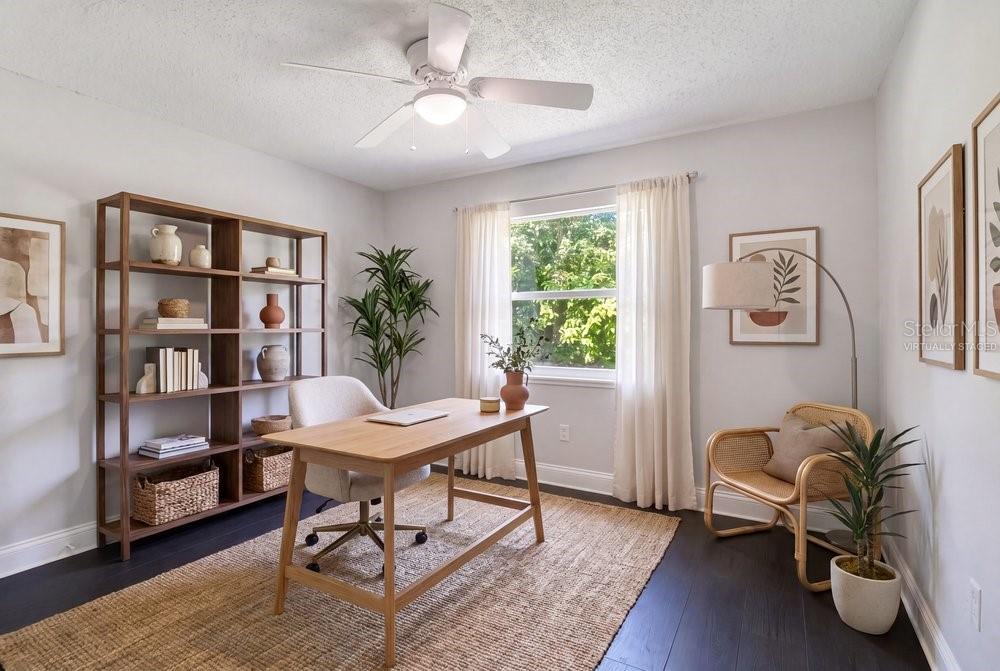 A home office with a wooden desk, bookshelf, rattan chair, and a large window — 156 LAKE DRIVE, ORLANDO, FL