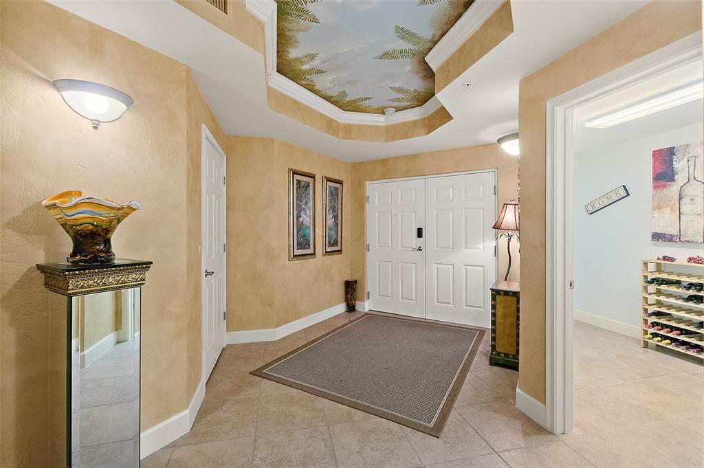 An entryway features a tray ceiling with a mural, tile floors, and a wine rack — 2403 S ATLANTIC AVENUE UNIT 1008, DAYTONA BEACH SHORES, FL