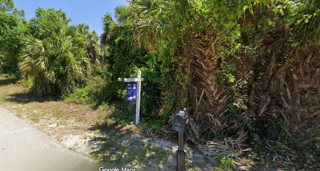 A for sale sign stands in front of a densely wooded, undeveloped residential lot — Lot 11 GEARY TERRACE, NORTH PORT, FL