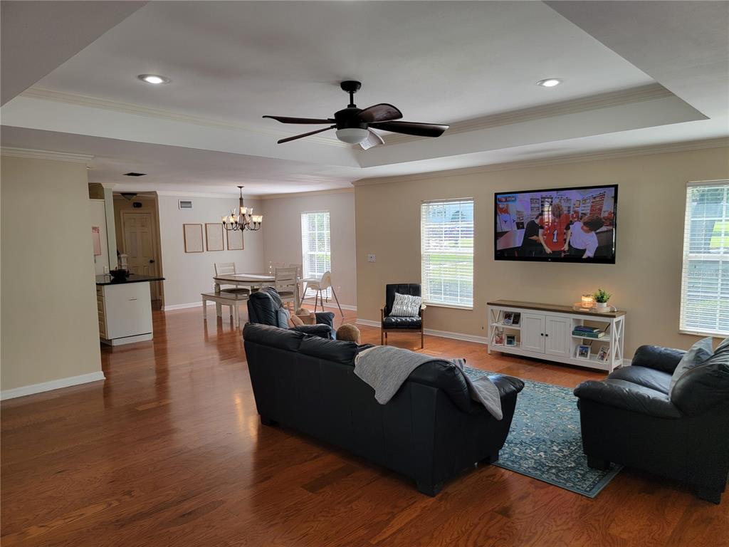 A living room with hardwood floors, a tray ceiling, and an open dining area — 4435 MOUNT VIEW DR, LAKELAND, FL