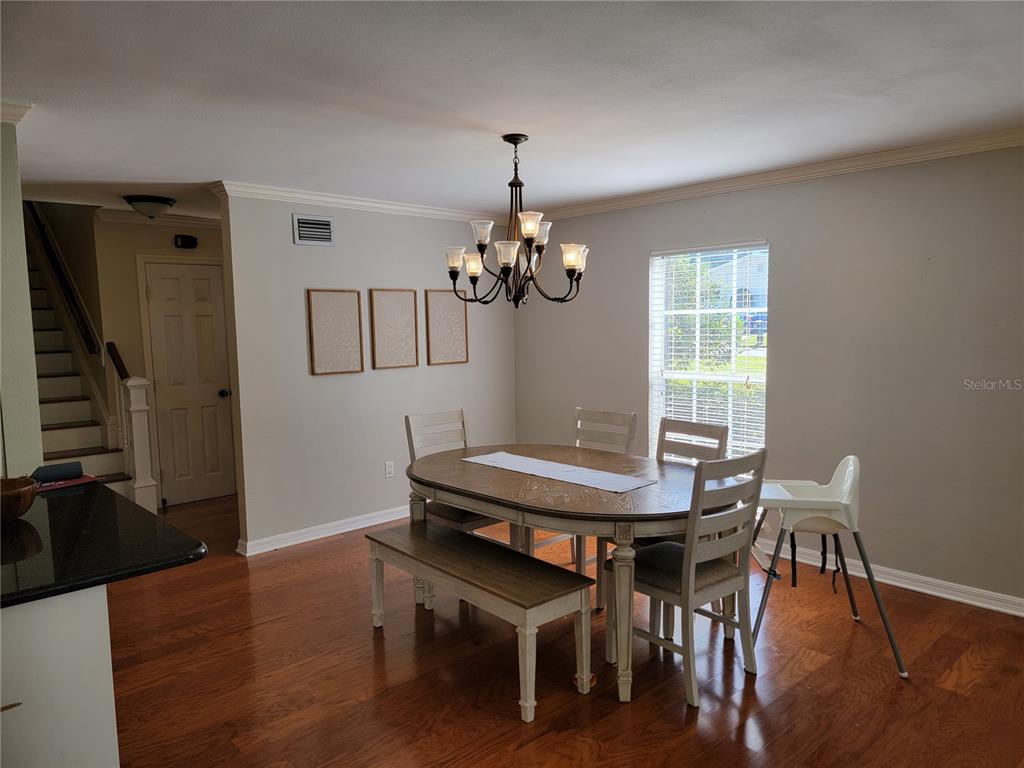 A dining room features a wooden table with a bench, chairs, and a chandelier — 4435 MOUNT VIEW DR, LAKELAND, FL
