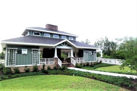 A green, single-story building with a covered porch, white railings, and a dark shingled roof — 1680 SW 188TH STREET, NEWBERRY, FL