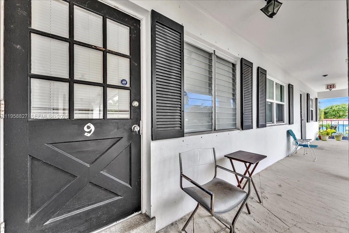 A black door with the number nine sits on a concrete walkway beside a window — 707 S 19th Ave # 9, Hollywood FL 33020, HOLLYWOOD, FL
