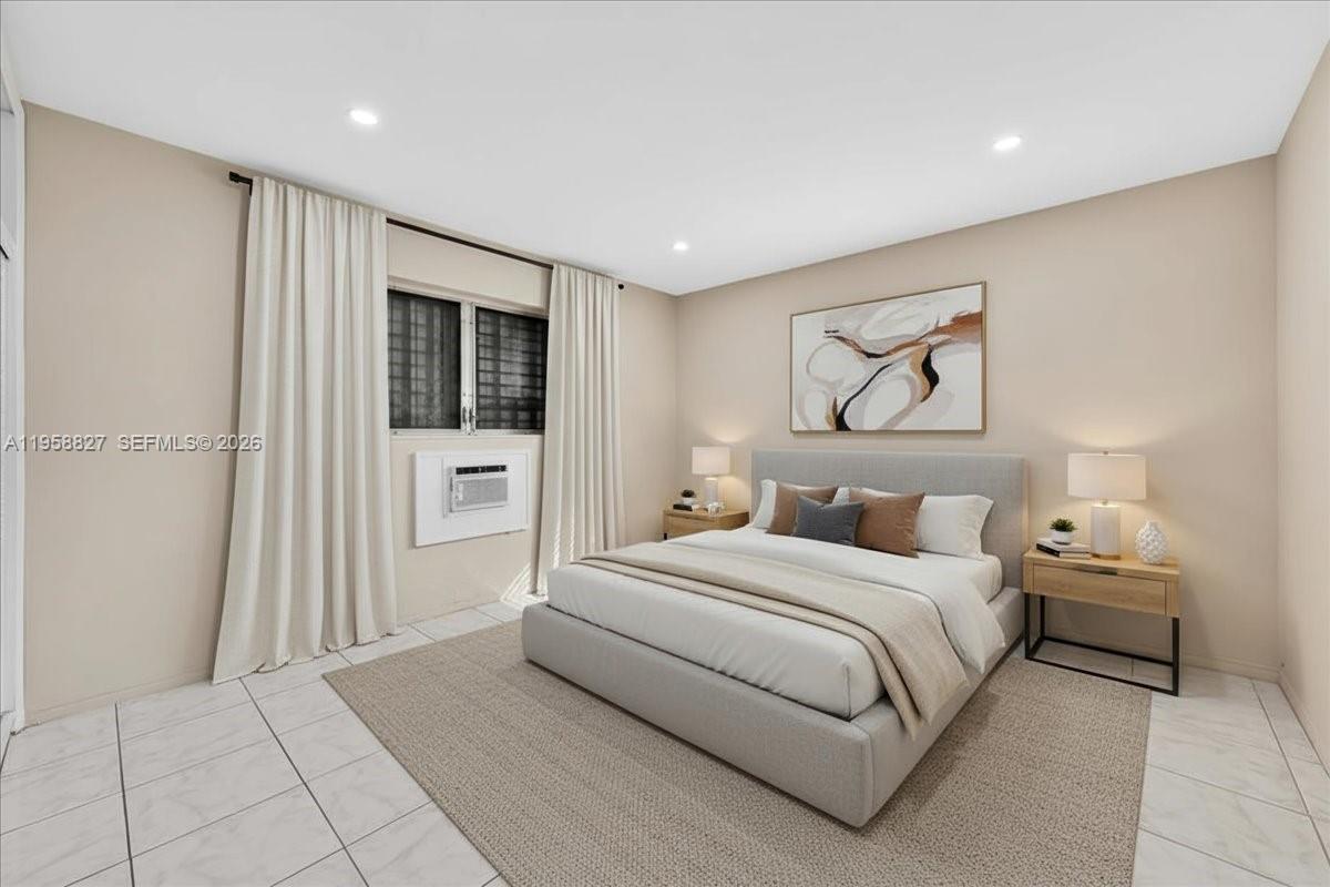 A bedroom features a bed with a light-colored frame, neutral walls, and tile flooring — 707 S 19th Ave # 9, Hollywood FL 33020, HOLLYWOOD, FL