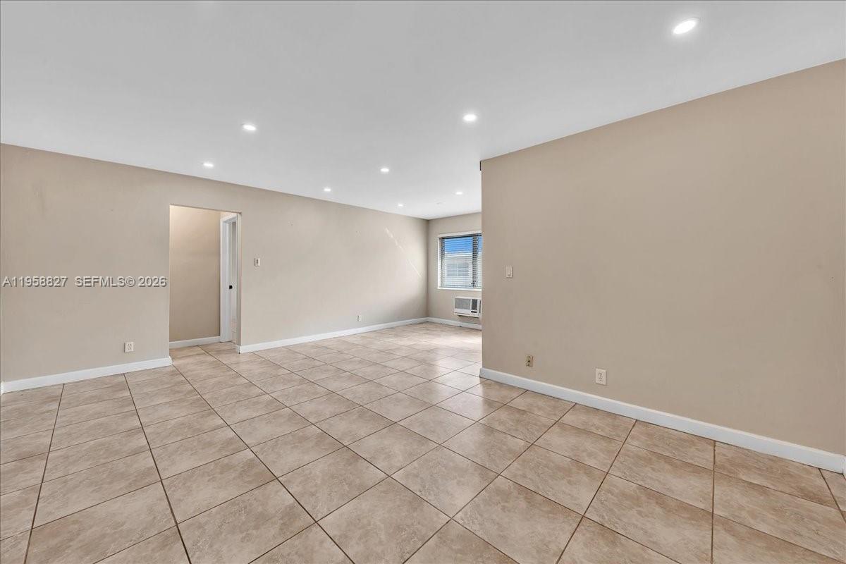 An empty room features beige walls, recessed lighting, and light-colored square floor tiles — 707 S 19th Ave # 9, Hollywood FL 33020, HOLLYWOOD, FL