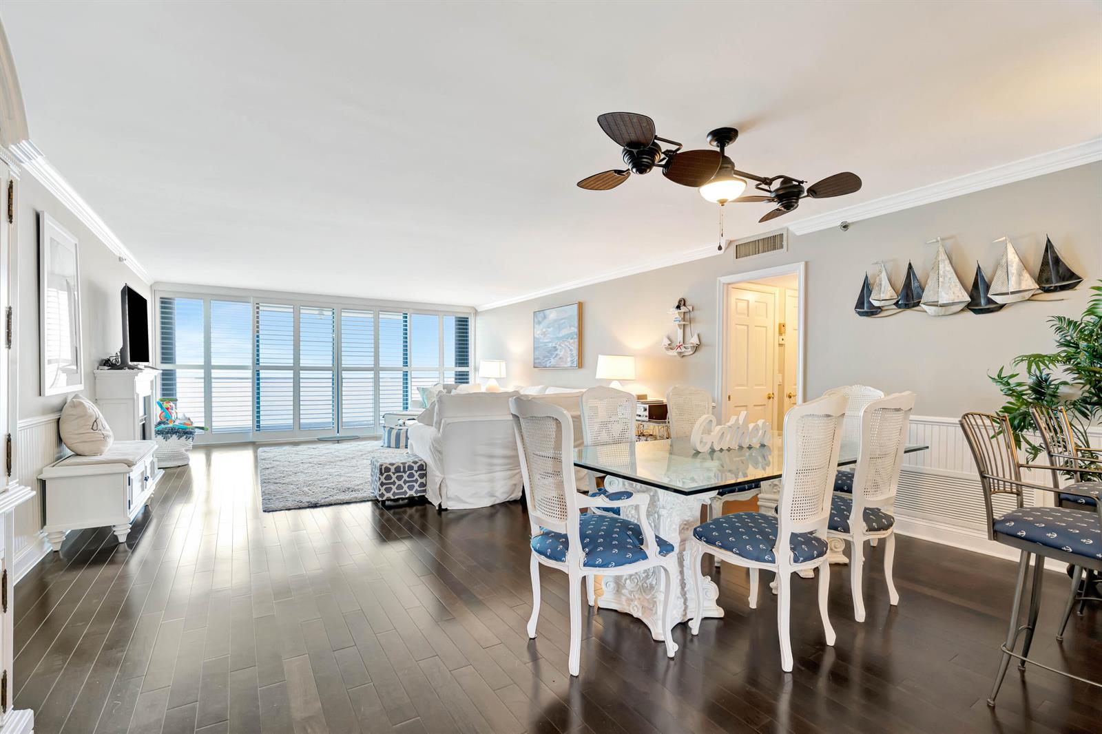 A bright living and dining area features dark wood floors, white furniture, and nautical decor — 100 S Beach Road, Jupiter FL 33469, JUPITER, FL