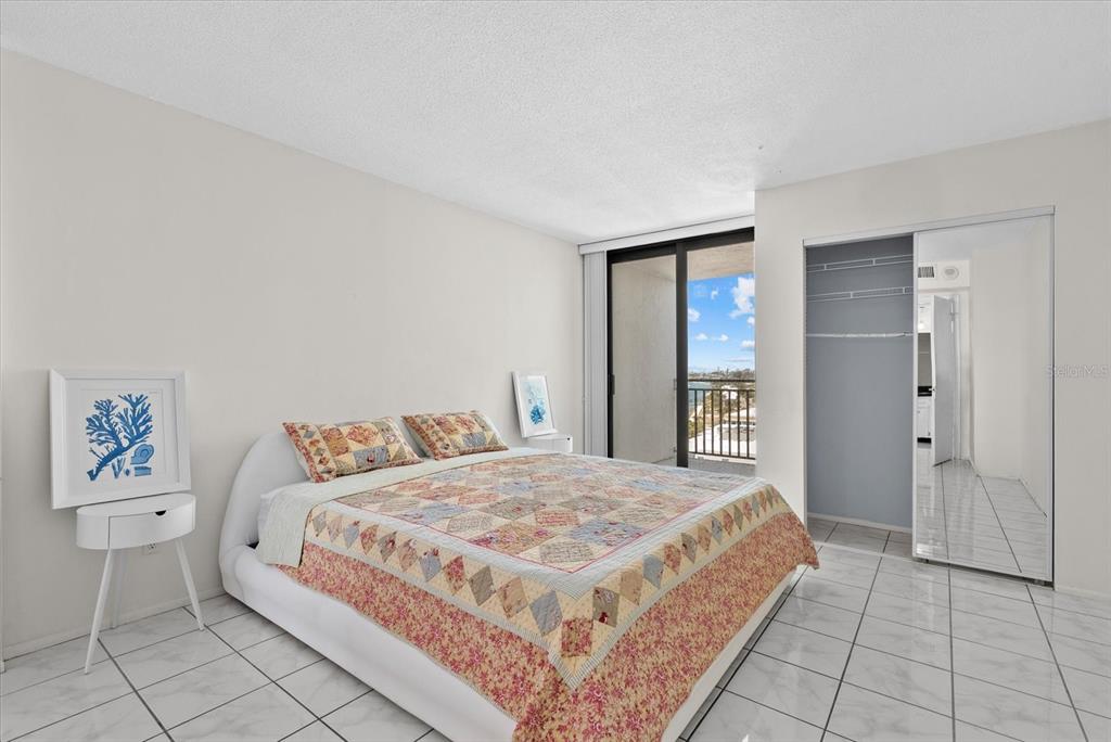 An elevated view of a coastal shoreline with modern buildings and a turquoise bay — 4822 OCEAN BOULEVARD UNIT 11E, SARASOTA, FL