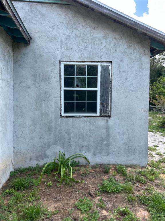 The exterior wall of a house features a single window with a wooden board filler — 108 PLANTATION LANE, WAVERLY, FL
