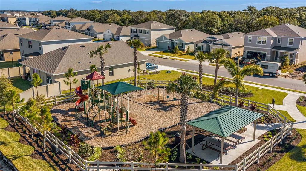 An aerial view of a neighborhood playground with a climbing structure and a covered pavilion — 17214 HARVEST MOON WAY, BRADENTON, FL