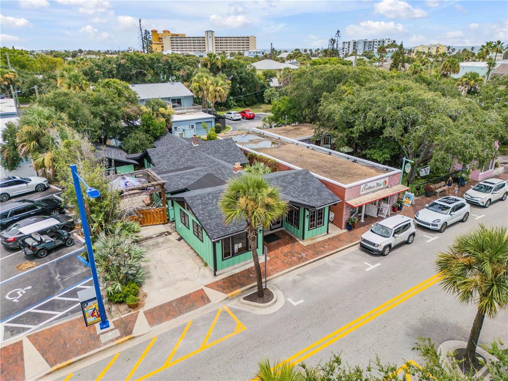 An aerial view shows a coastal town with a red location pin over a building — 304 FLAGLER AVENUE, NEW SMYRNA BEACH, FL