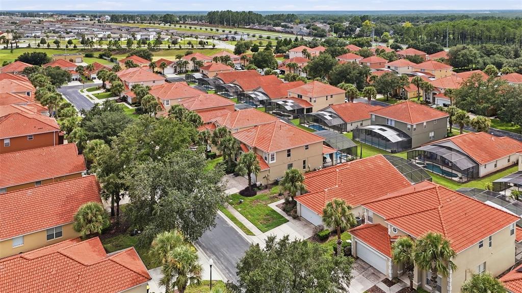 An aerial view shows a suburban neighborhood with many houses featuring orange tile roofs — 165 SEVILLA AVENUE, DAVENPORT, FL