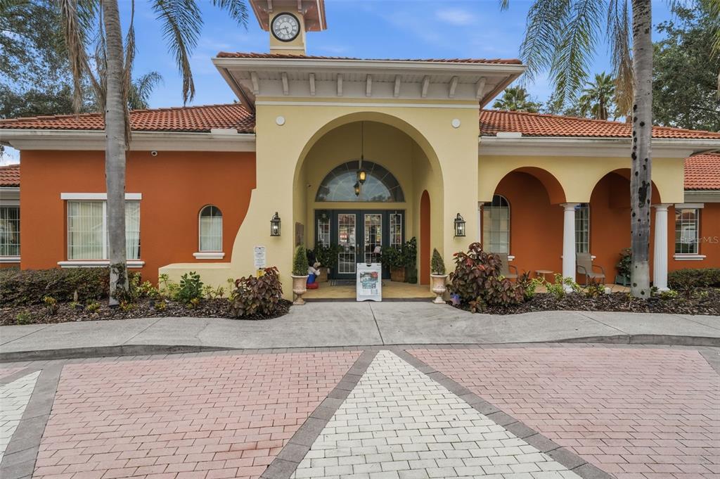 The exterior of a Mediterranean-style building features a central clock tower, arched entryway, and terracotta roof — 165 SEVILLA AVENUE, DAVENPORT, FL