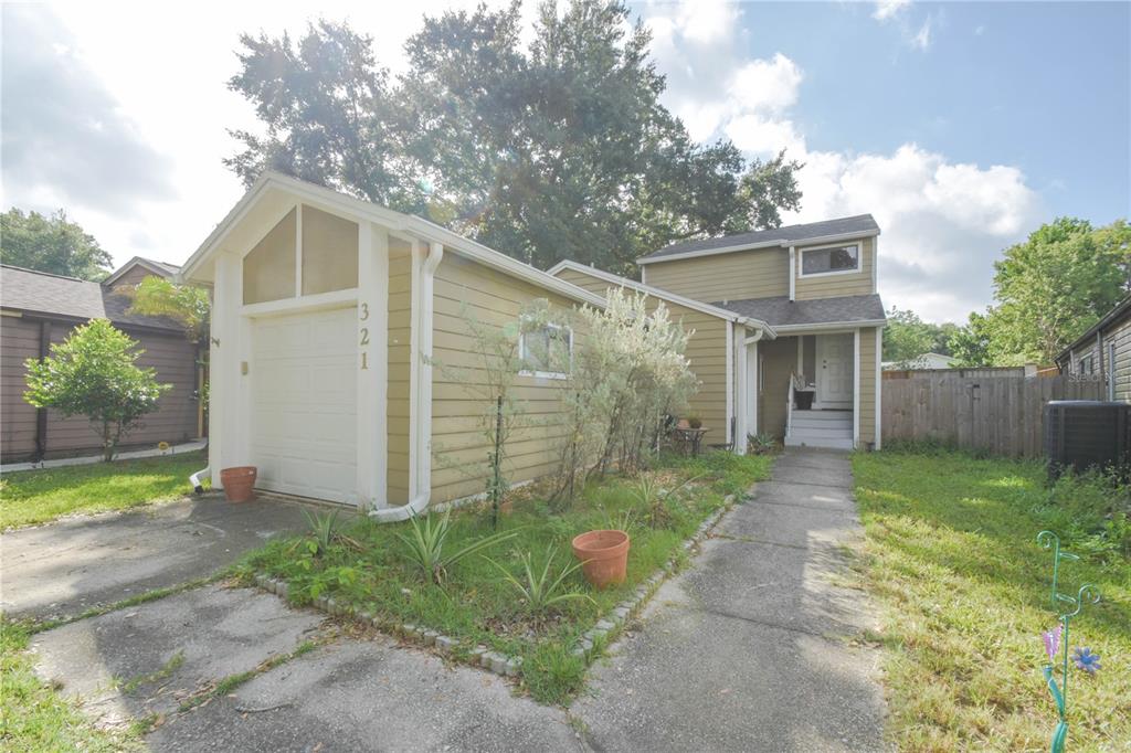 A tan house with a single-car garage, a concrete driveway, and a front walkway — 321 KIRKCALDY DRIVE, WINTER SPRINGS, FL