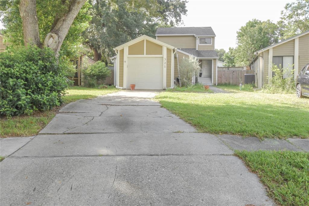 A tan two-story house with a concrete driveway and a single-car garage — 321 KIRKCALDY DRIVE, WINTER SPRINGS, FL