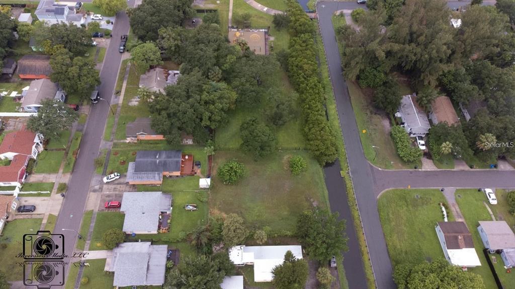 An aerial view shows a vacant residential lot situated between houses and a drainage canal — 26TH AVENUE S, ST PETERSBURG, FL