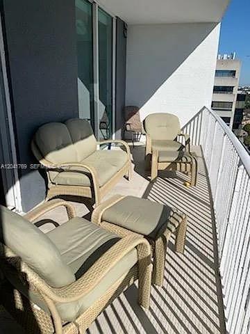 A balcony features a wicker loveseat, two matching chairs, and a small ottoman — 3180 SW 22nd Ter, Miami FL 33145, MIAMI, FL