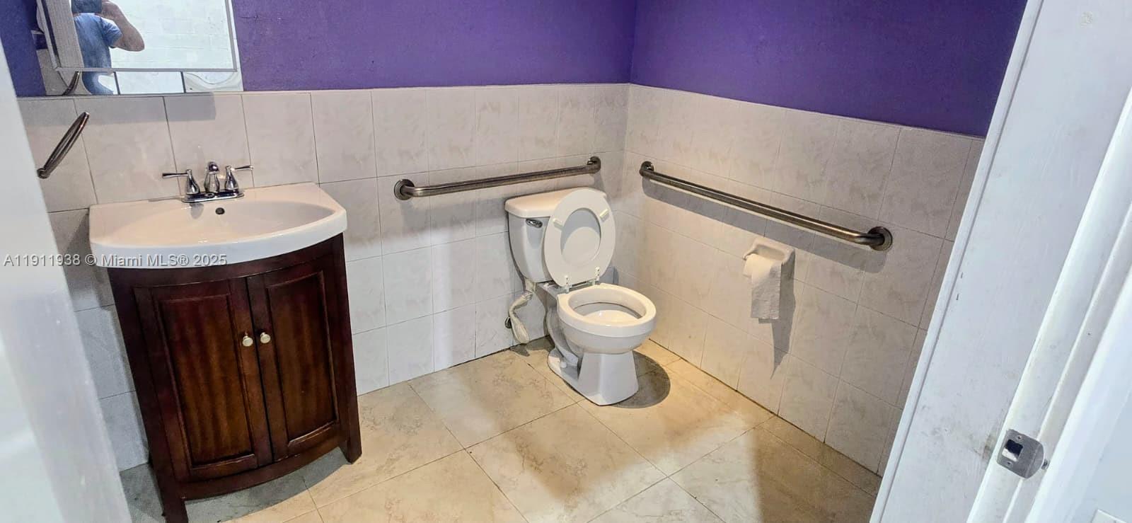 A bathroom features a vanity, a toilet with grab bars, and purple-painted walls — 2954 W 84th St # 118, Hialeah FL 33018, HIALEAH, FL
