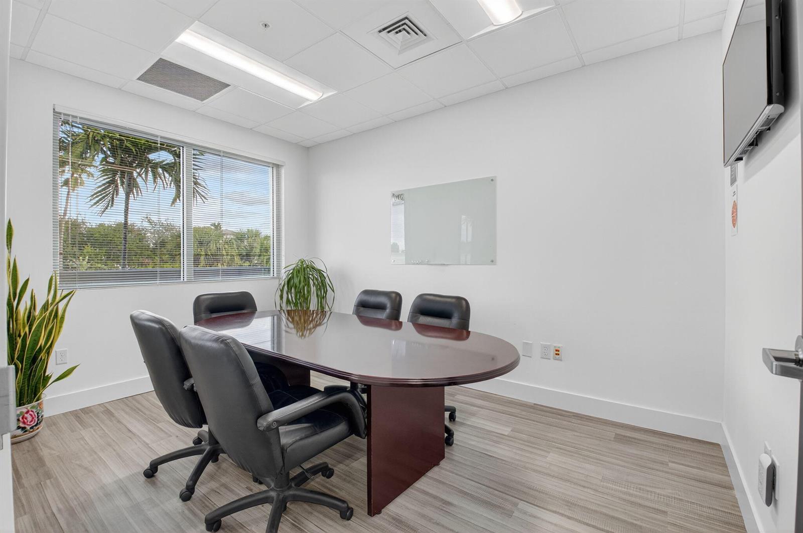 A small conference room features a dark oval table, black chairs, and a glass whiteboard — 7700 Congress Avenue # 3211, Boca Raton FL 33487, BOCA RATON, FL