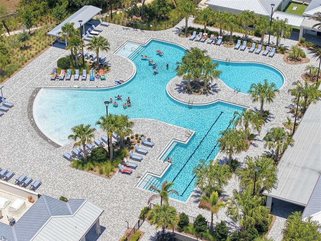 An aerial view shows a large, irregularly shaped swimming pool surrounded by lounge chairs — 17135 SHELL BAY DRIVE, LAND O LAKES, FL