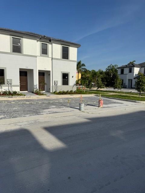 A two-story residential building with a paved driveway and a clear blue sky — FLORIDA CITY, FL